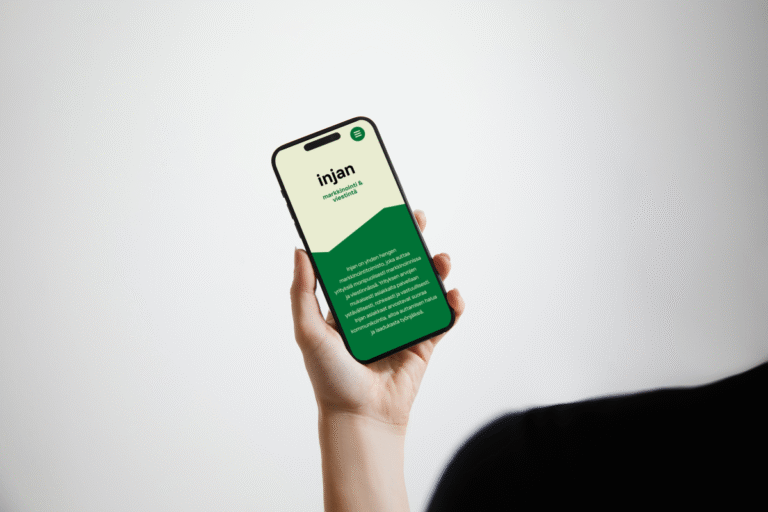 Kuvituskuva: Kädessä puhelin, jossa näkyy Injan verkkosivut.